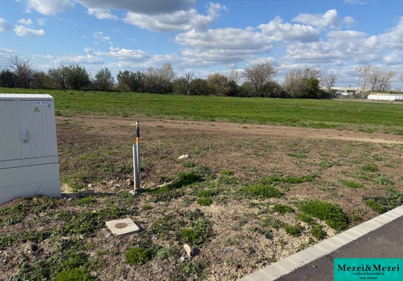 Commercial land in Trnava with a grassy area and an electrical distribution box for sale.