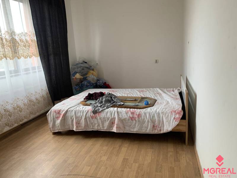 A bedroom in a family house with a bed and a wooden decor floor.