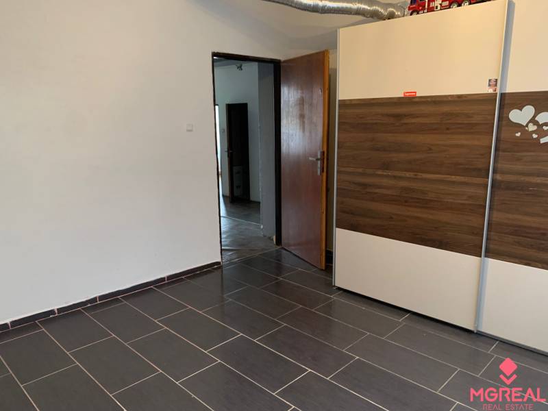 Interior of a family house with tiled flooring and a built-in wardrobe with a wooden decor.