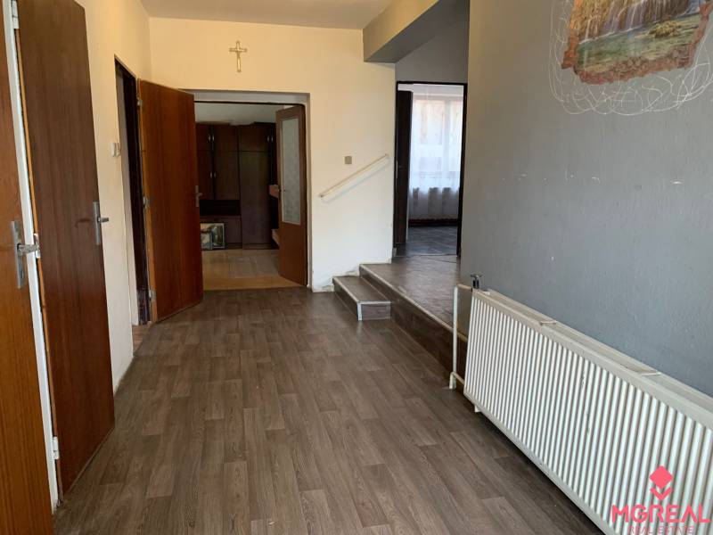 A hallway in a family house with a wooden decor floor and wooden doors.