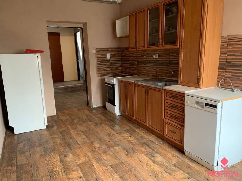 A kitchen in a family house with a wooden decor floor and brown cabinets.