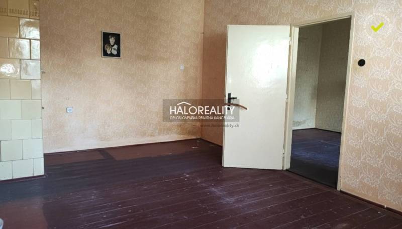 A room in a family house with a wooden decor floor and wallpaper.