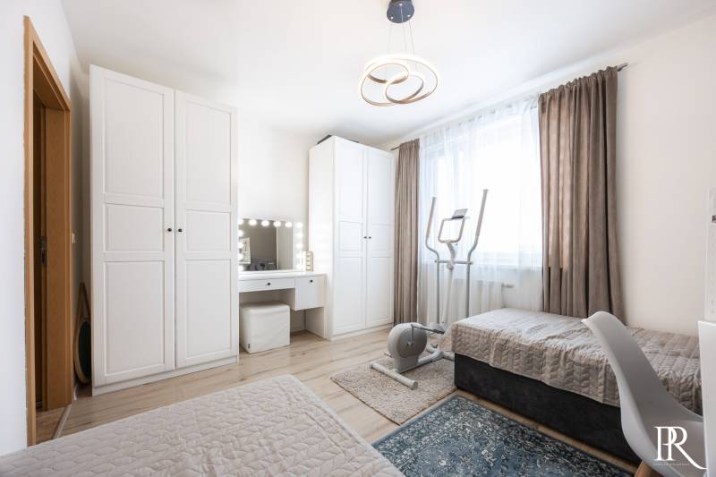 Bedroom in a 2-room apartment with a bed, wardrobes, and exercise equipment.