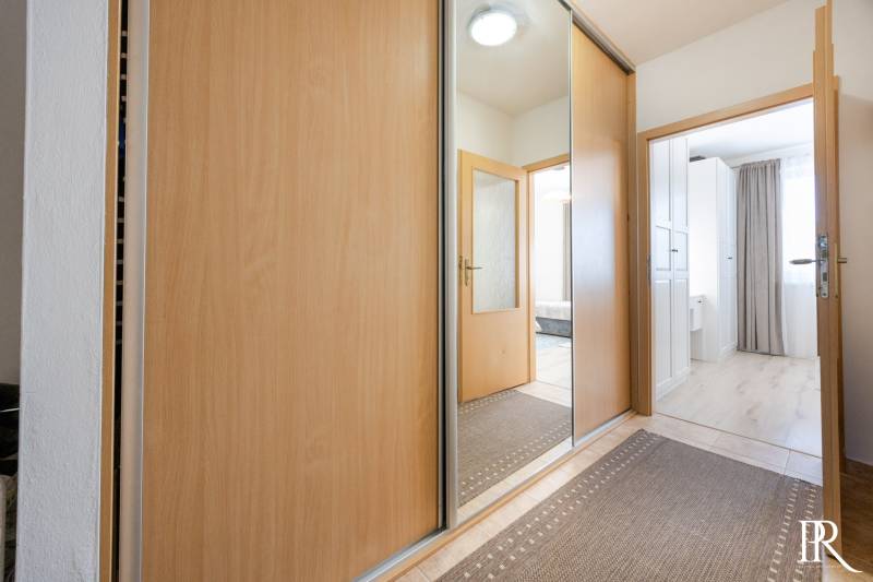 A hallway with a large mirror and built-in wardrobes in a 2-room apartment.