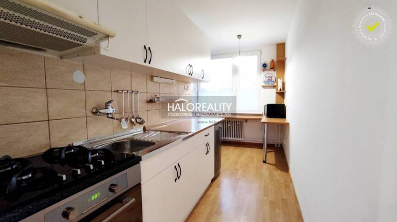 Kitchen and 2-room apartment with white cabinets, a gas stove, and a large window.