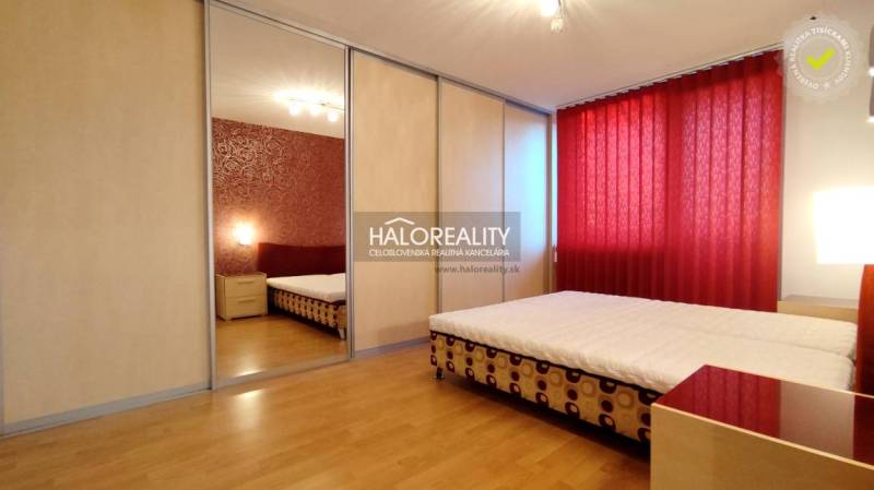 A bedroom with red curtains, a built-in wardrobe, and a double bed in a two-room apartment.