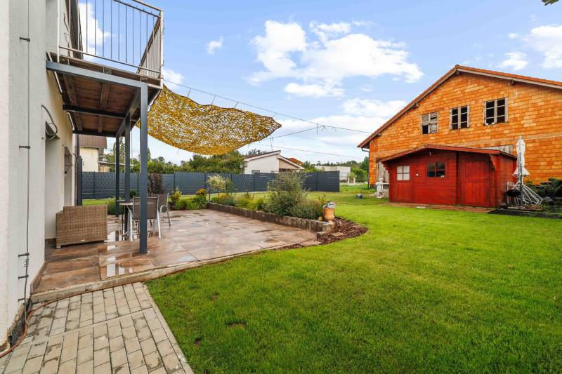 The garden of the family house on Breitensee Street in the town of Marchegg, with a terrace and a shelter.
