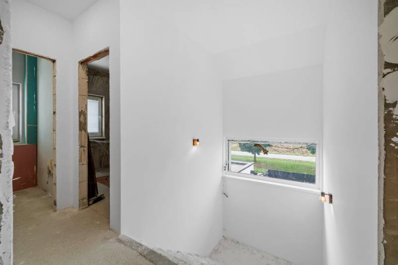 Interior renovation in a family house with white walls and a window to the exterior.