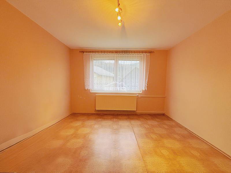A room in a family house with orange walls and a wooden decor floor.