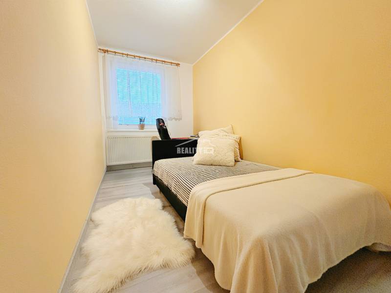 Cozy bedroom with a bed, carpet, and window in a family house.