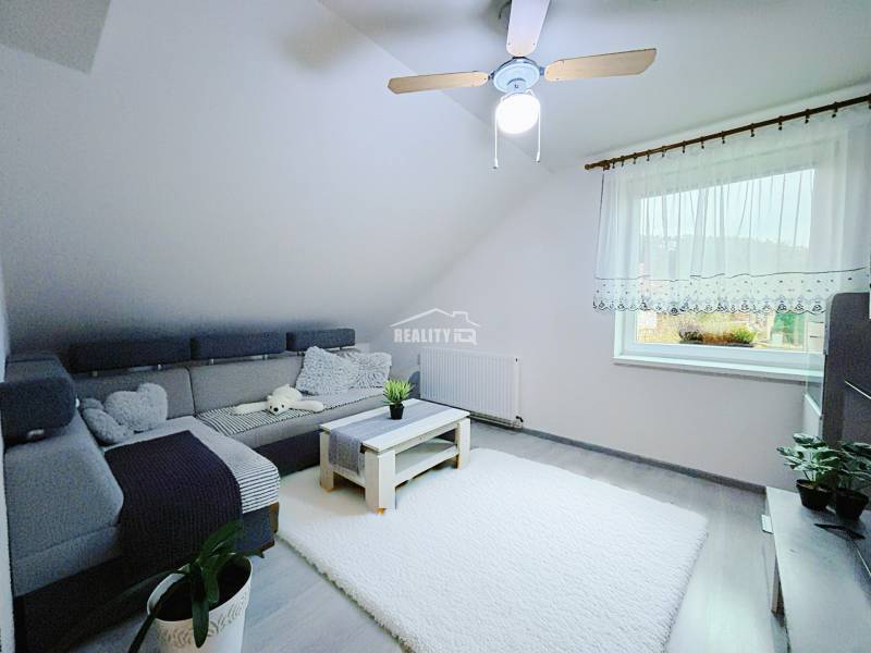 Living room in a family house with a corner sofa and a white carpet.