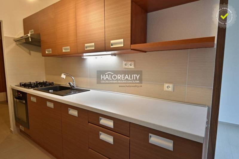 A kitchen unit with a wooden decor, appliances, and storage spaces in a 2-room apartment.