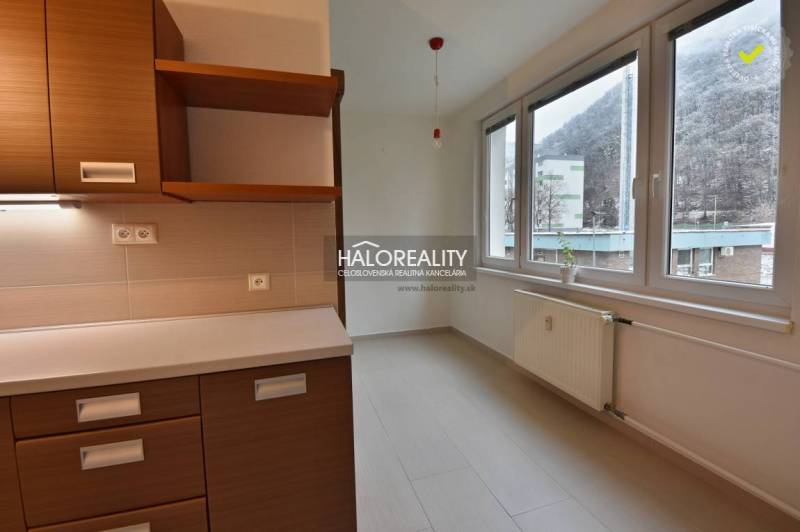 Kitchen unit and windows with a view in a 2-room apartment, floor with wood decor.