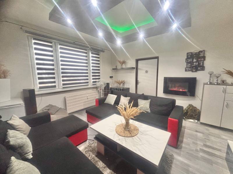 Living room in a 3-room apartment with a fireplace and a wooden decor floor.