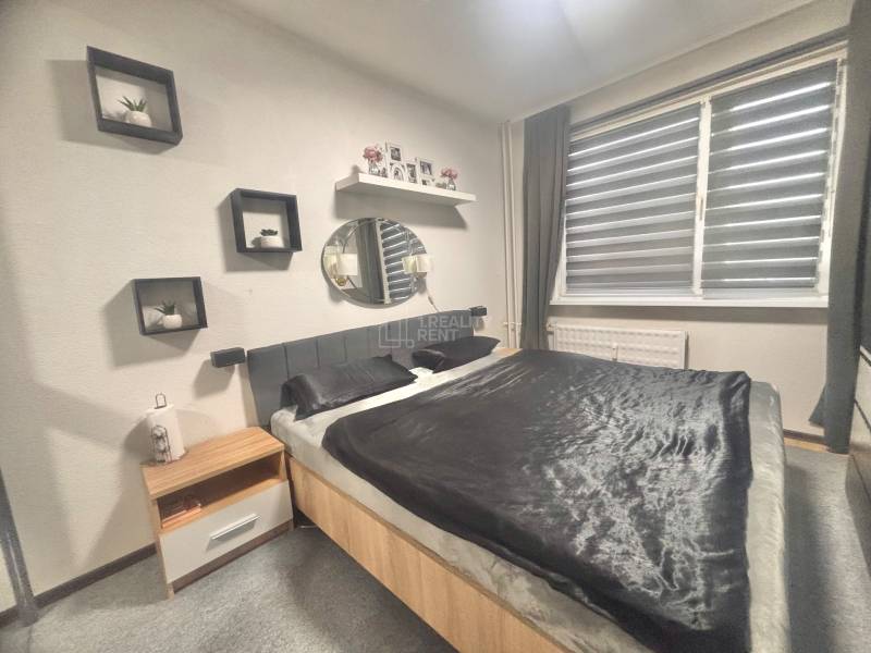 Bedroom in a 3-room apartment, double bed, nightstand, wall decorations.