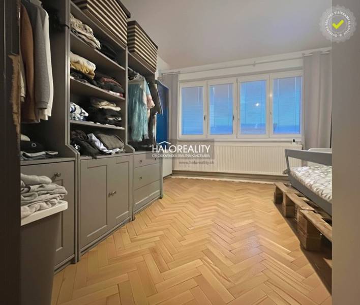 A room with a wooden floor decor, a wardrobe, and a children's bed.