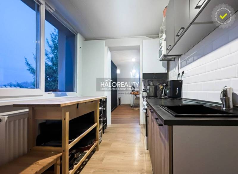 Kitchen in a 3-room apartment with a wood-patterned floor, white tiles, compact interior.