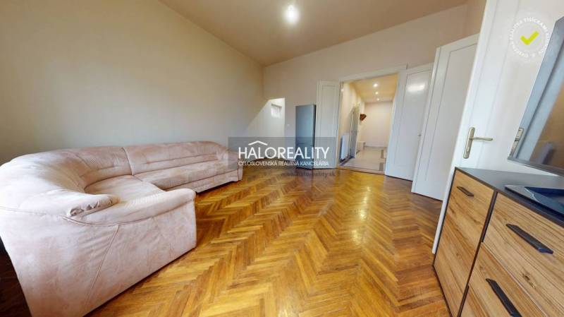 Living room in a 3-room apartment with a corner sofa and a floor with a wooden decor.