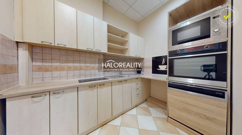 A kitchen with light cabinets, a cooktop, and an electric oven in a 3-room apartment.