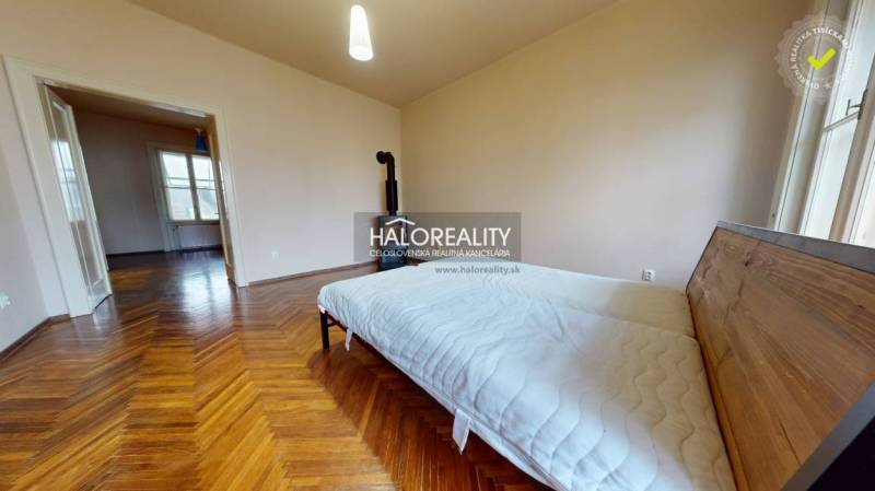 A bedroom in a 3-room apartment with a bed and a wooden decor floor.