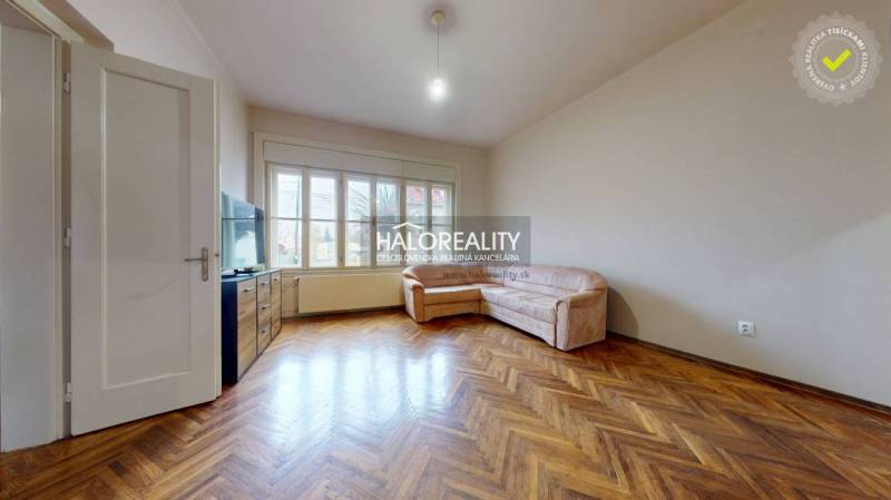 Living room in a three-room apartment with wooden decor and a corner sofa.