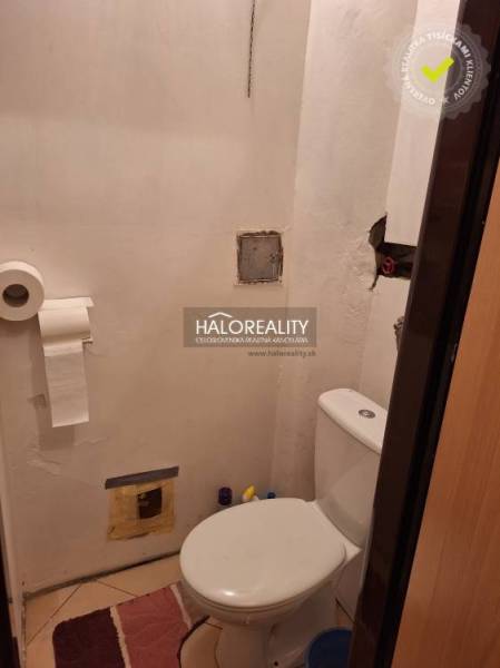 Bathroom with toilet in a 3-room apartment, white walls, toilet, tiled floor.