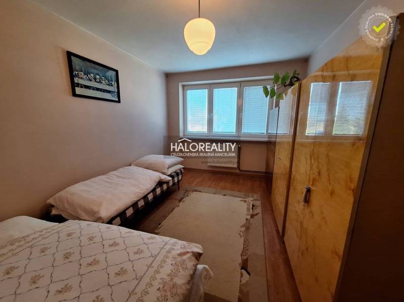 A bedroom with two beds and a wooden decor floor in a three-room apartment.