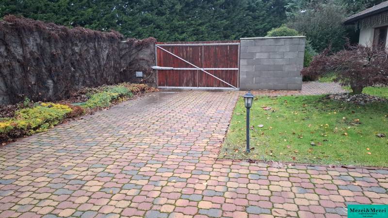 Outdoor paving and gate in a family house in Bohdanovce nad Trnavou, surrounded by greenery and trees.