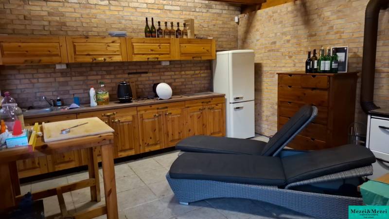 A kitchen in a family house with brick walls and wooden cabinets.