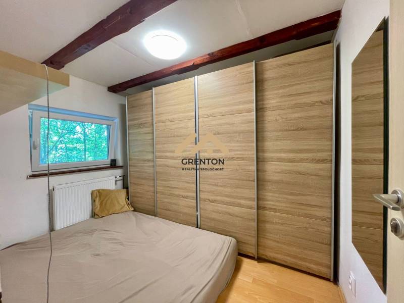 A bedroom in a cottage with a wood-decor floor and a built-in wardrobe.