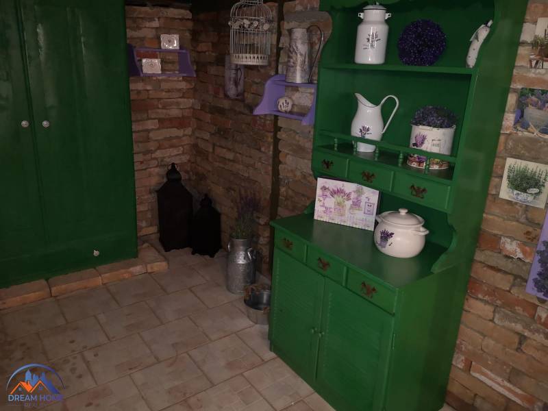 A family house with a brick wall, green furniture, and decorations with a lavender motif.