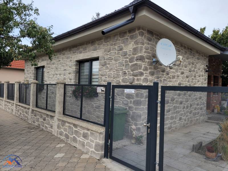 The family house in Okoličná na Ostrove has a stone facade and a satellite dish.