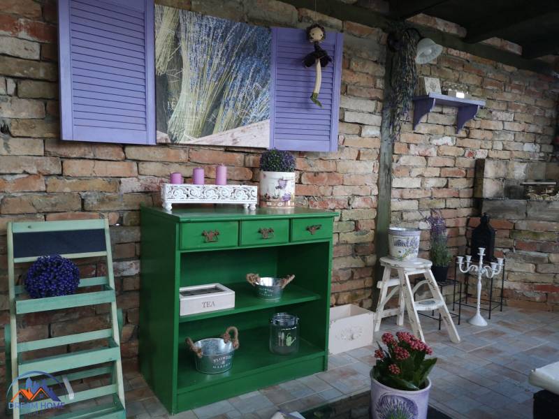 Interior with a green dresser, lavender, and a brick wall in a family house.