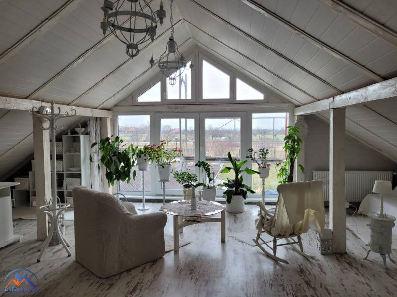 Attic room of a family house with a rocking chair and a wooden decor floor.