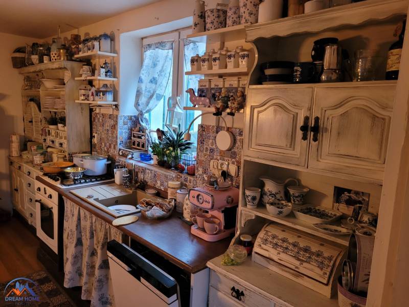 Vintage kitchen in a family house with decorations and ceramic dishes, floor with wooden decor.