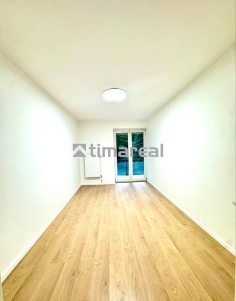 White room in a 4-room apartment with a wood-patterned floor and balcony doors.