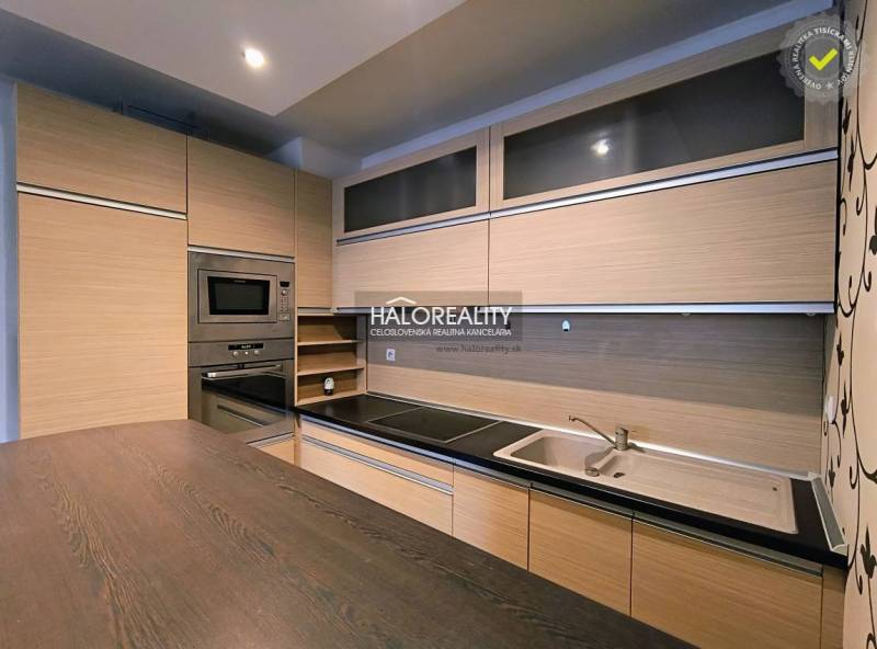 A kitchen in a 2-room apartment with a wooden decor floor and built-in appliances.