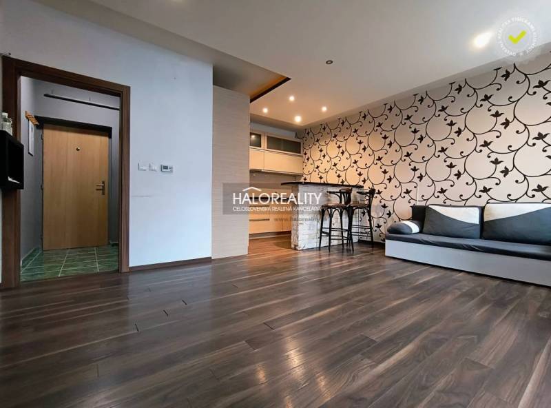 Interior of a 2-room apartment with a wooden decor floor and patterned wallpaper on the wall.