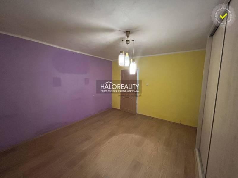 A room in a 2-room apartment with purple and yellow walls, a floor with a wooden decor.