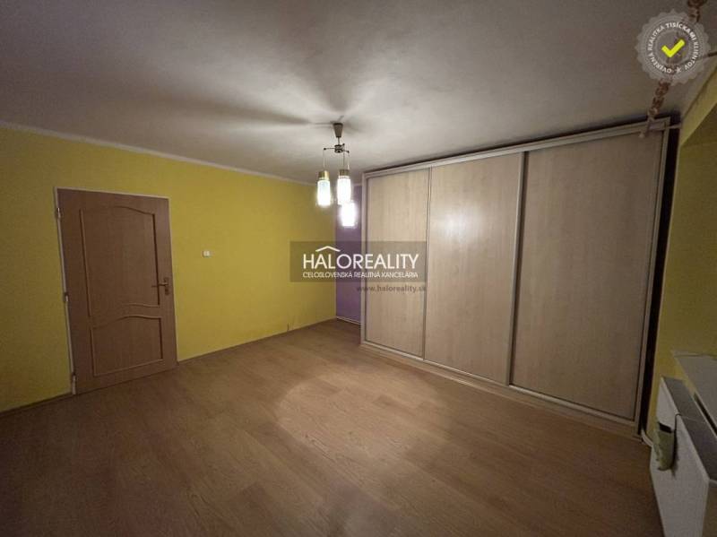 A room in a 2-room apartment with a floor featuring a wooden decor and a built-in wardrobe.