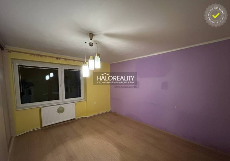 A room in a 2-room apartment with a purple wall, floor with wood decor.