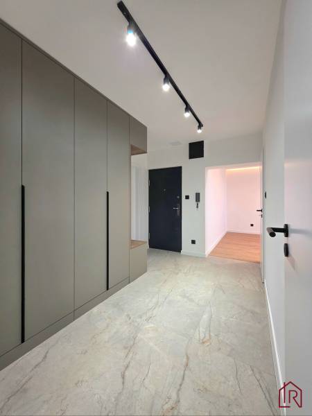 Entrance hallway of a 3-room apartment with a large wardrobe and tiles with a natural pattern.