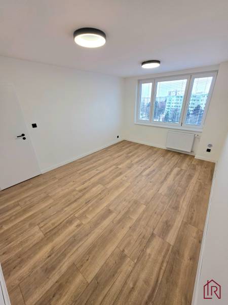 A place in a 3-room apartment with a wooden decor floor and ceiling lights.