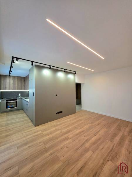 3-room apartment with wood-patterned flooring and a built-in kitchen.