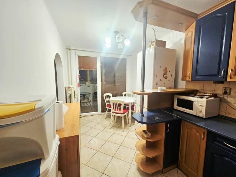 A kitchen with a dining area in a 3-room apartment, white walls, blue cabinets, ceramic tiles.