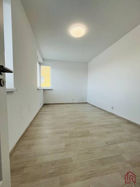 An empty room with a wooden decor floor in a 3-room apartment.