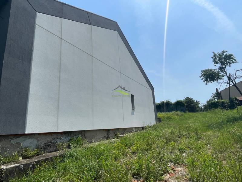 A family house in Koromľa with a simple facade is situated on a plot with a grassy area.