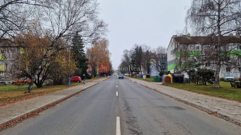 Banícka Street in Poprad is lined with trees and buildings, suitable for a 2-room apartment.