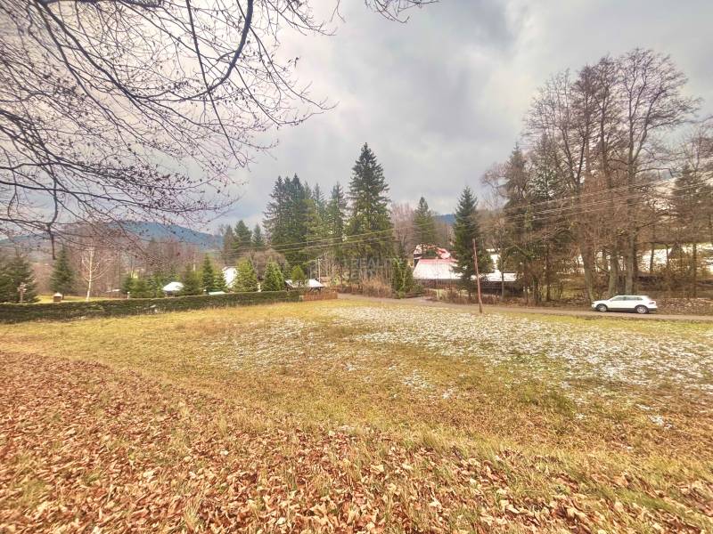 Autumn panorama of residential plots in Makov, Čierne, surrounded by trees and a road with a car.
