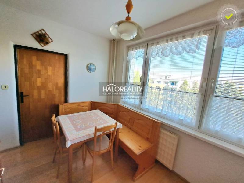 Dining room in a 3-room apartment with a wooden decor floor and large windows.